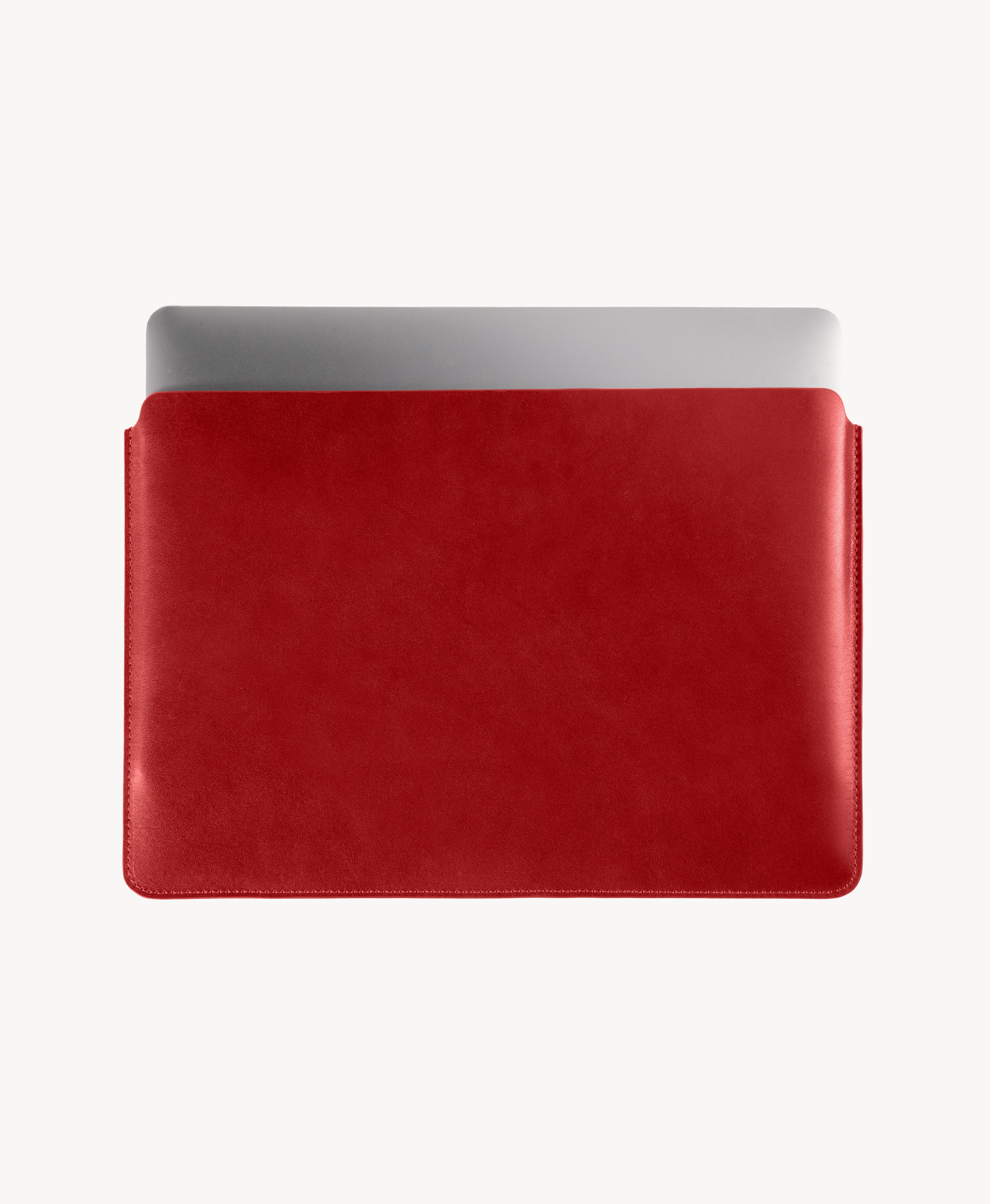 Red full grain saddle leather laptop sleeve, MacBook partially inserted through the open top