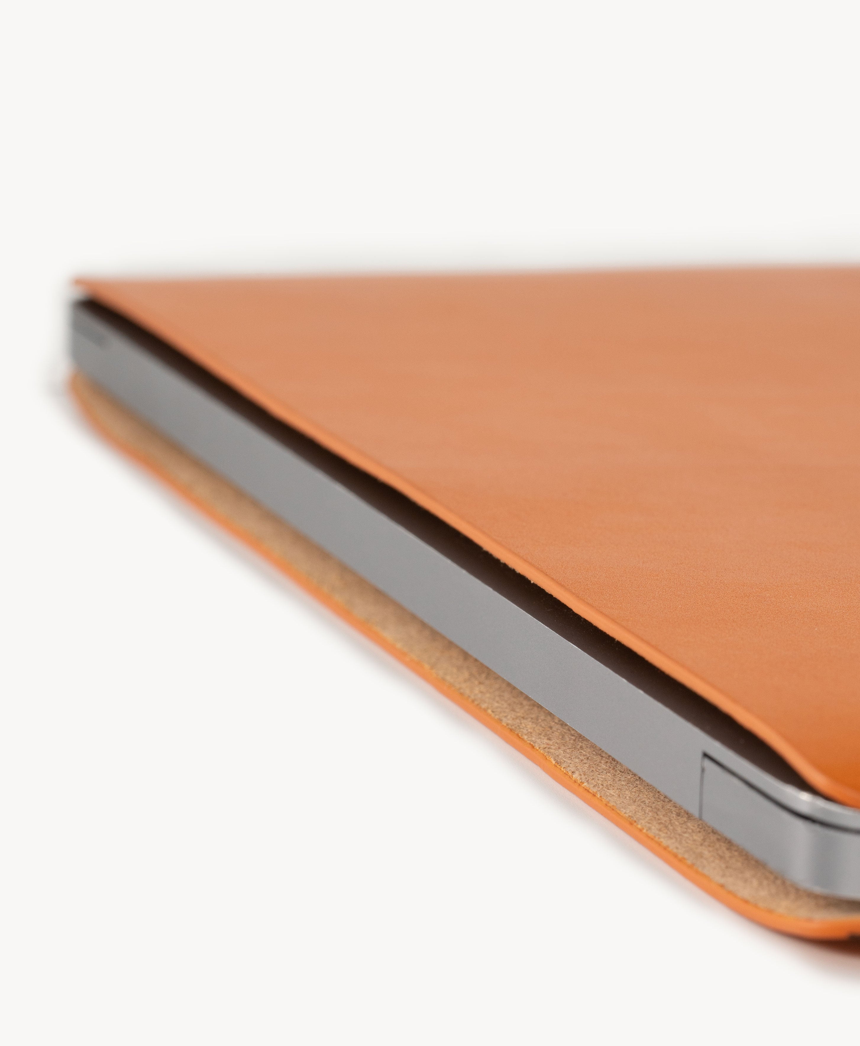 Honey Tan full grain saddle leather laptop sleeve, slim side profile with a MacBook inserted