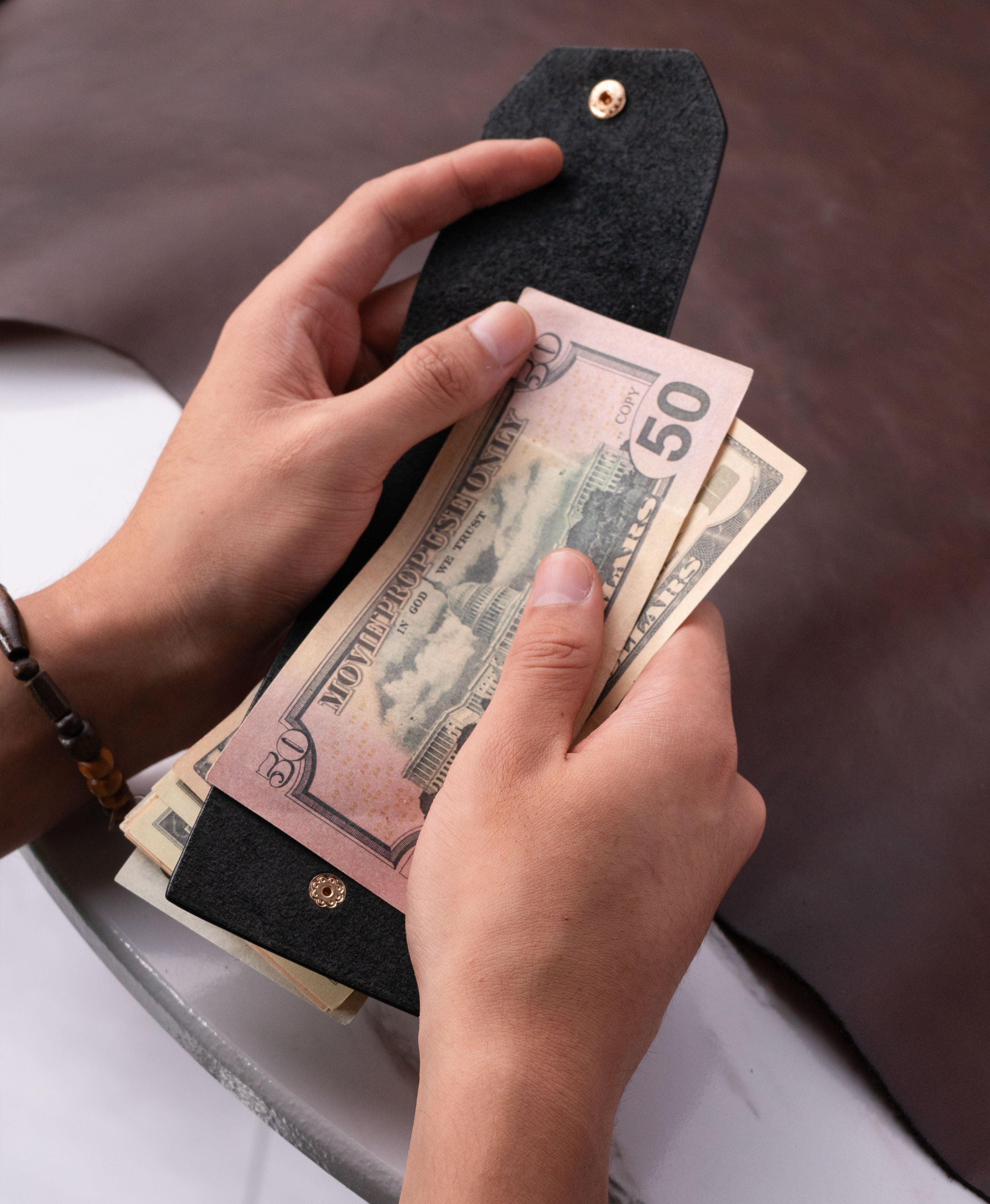 Black full-grain saddle leather cash wrap wallet lifestyle view 2