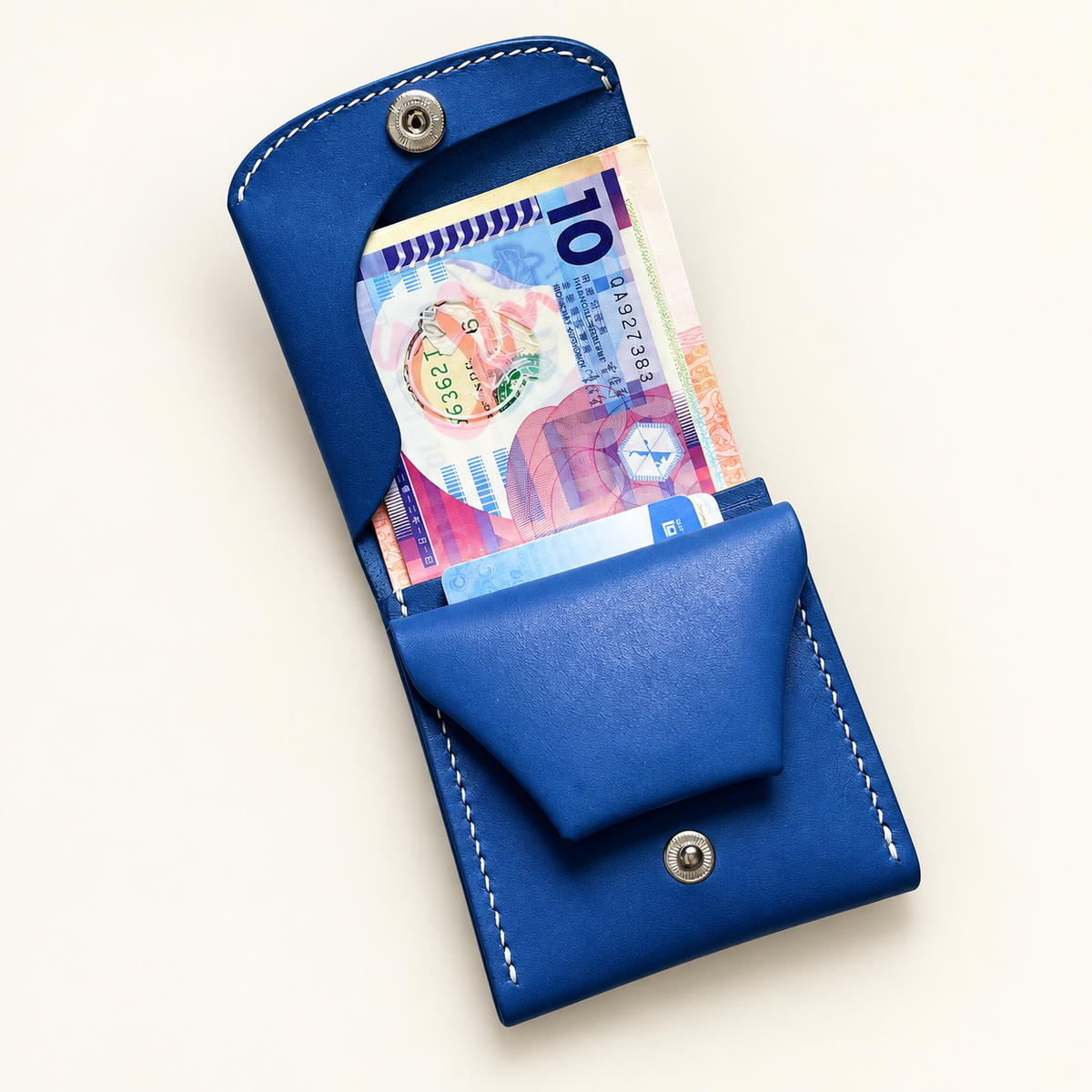 Carteira de couro azul aberta para mostrar notas e armazenamento de cartões