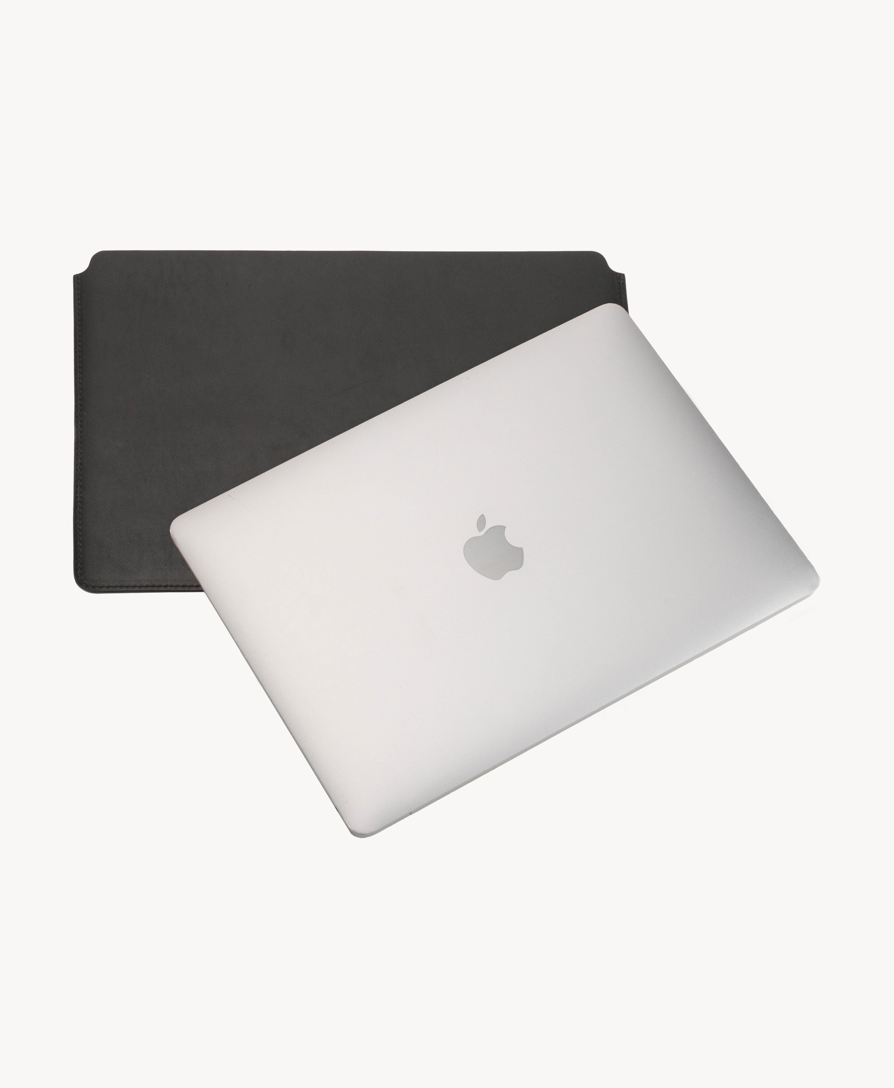 Black full grain saddle leather laptop sleeve, shown with a MacBook