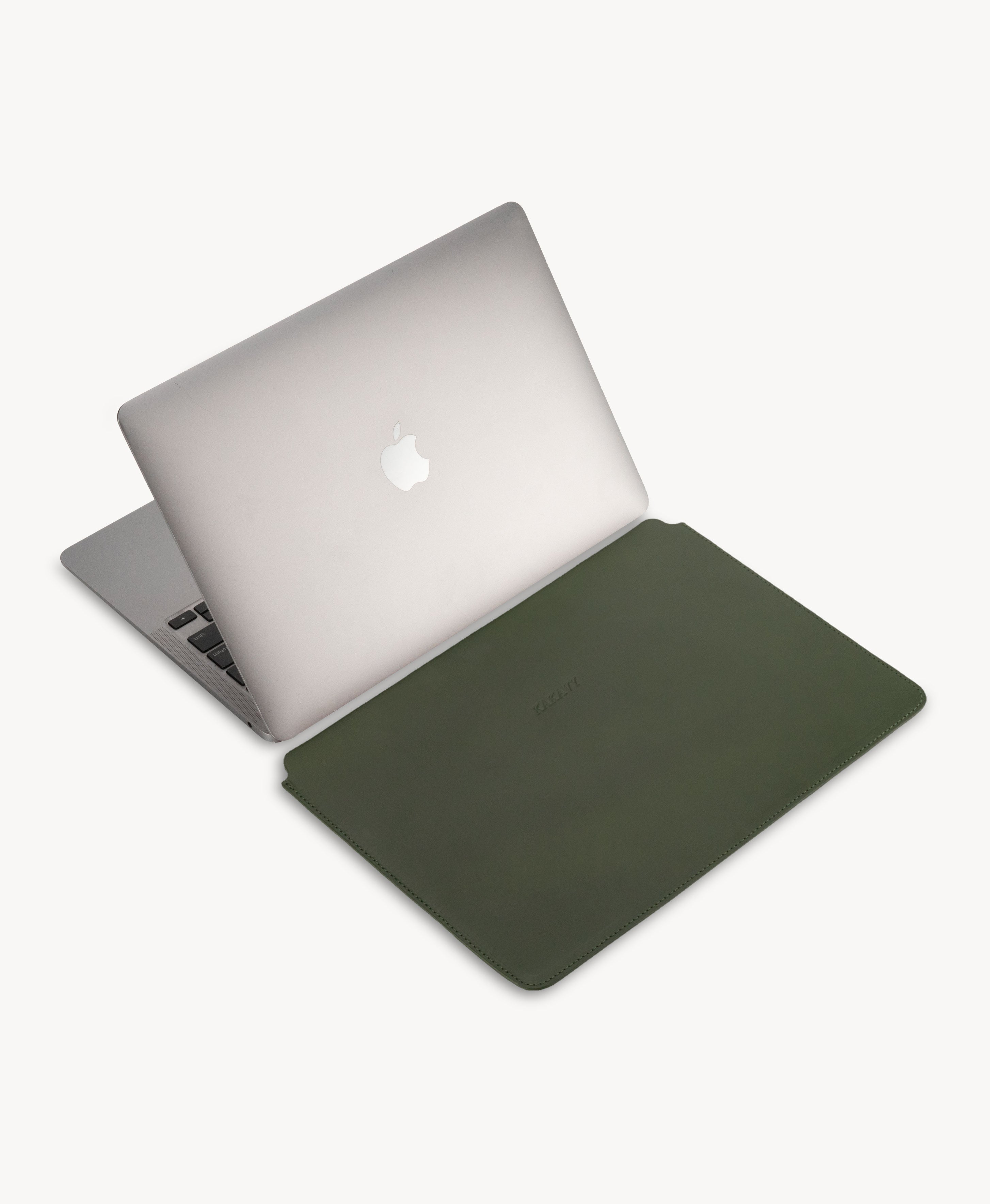 Forest Green full grain saddle leather laptop sleeve, beside an open MacBook