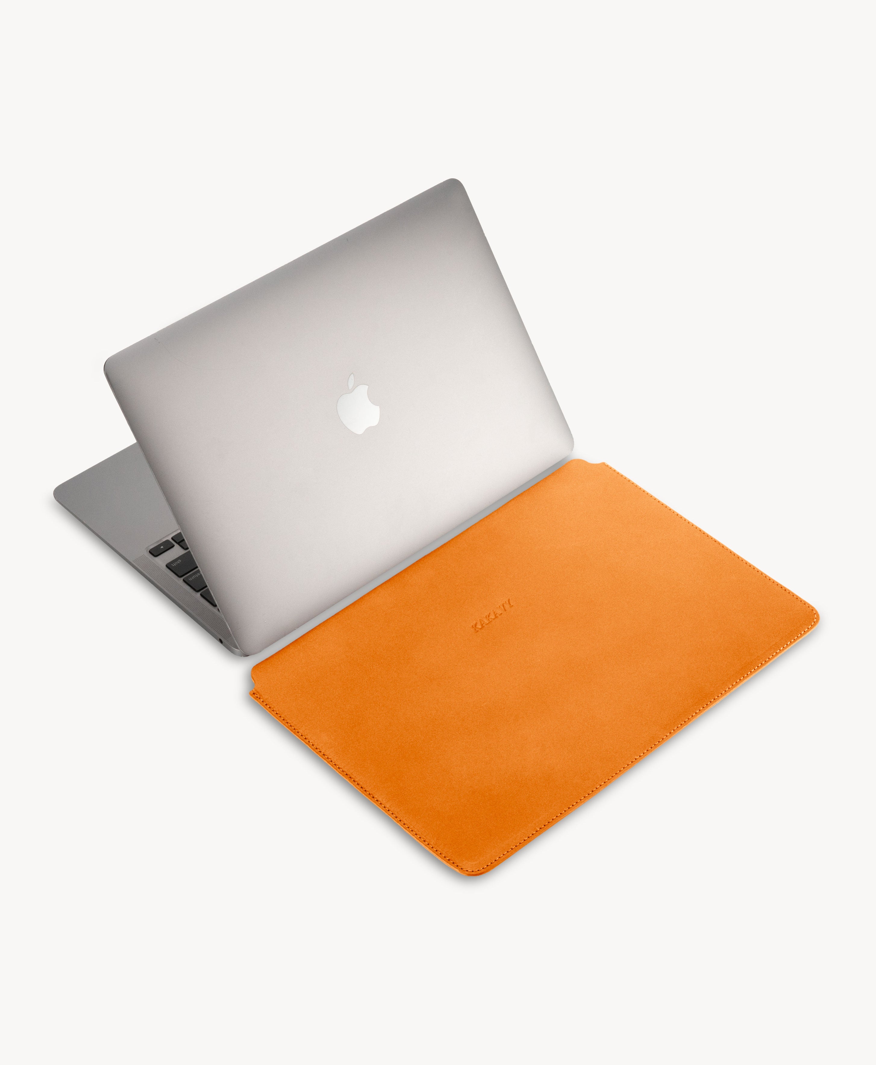 Honey Tan full grain saddle leather laptop sleeve, beside an open MacBook