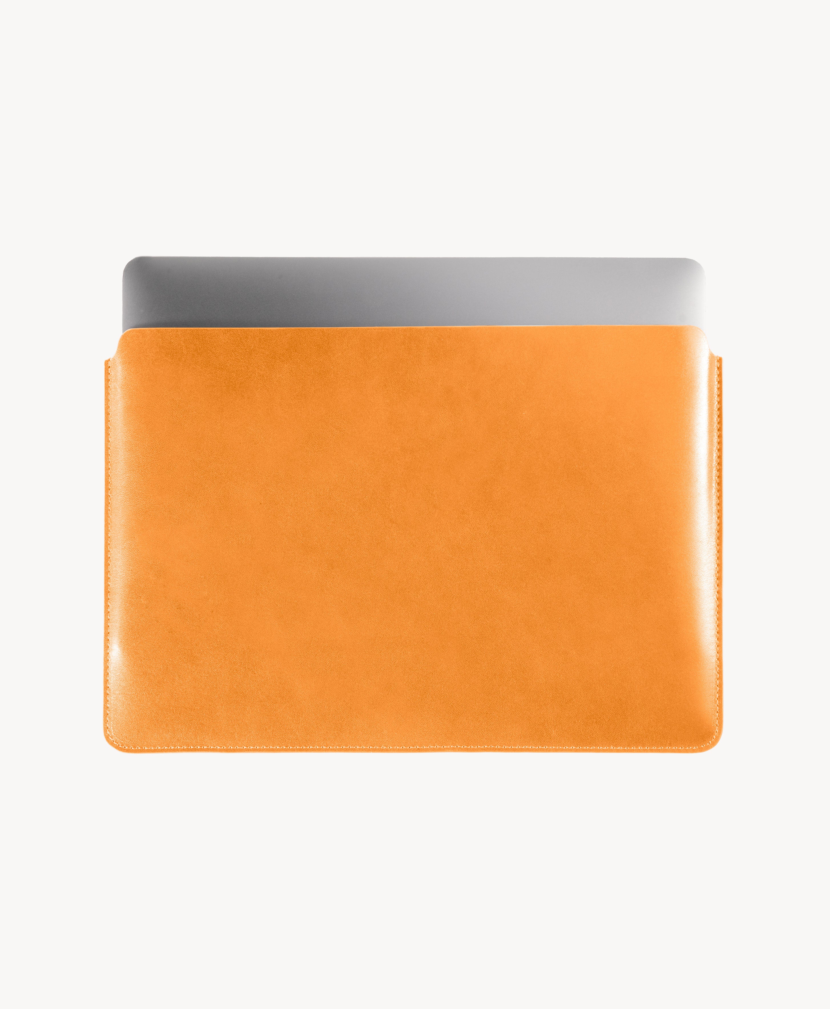 Honey Tan full grain saddle leather laptop sleeve, MacBook partially inserted through the open top