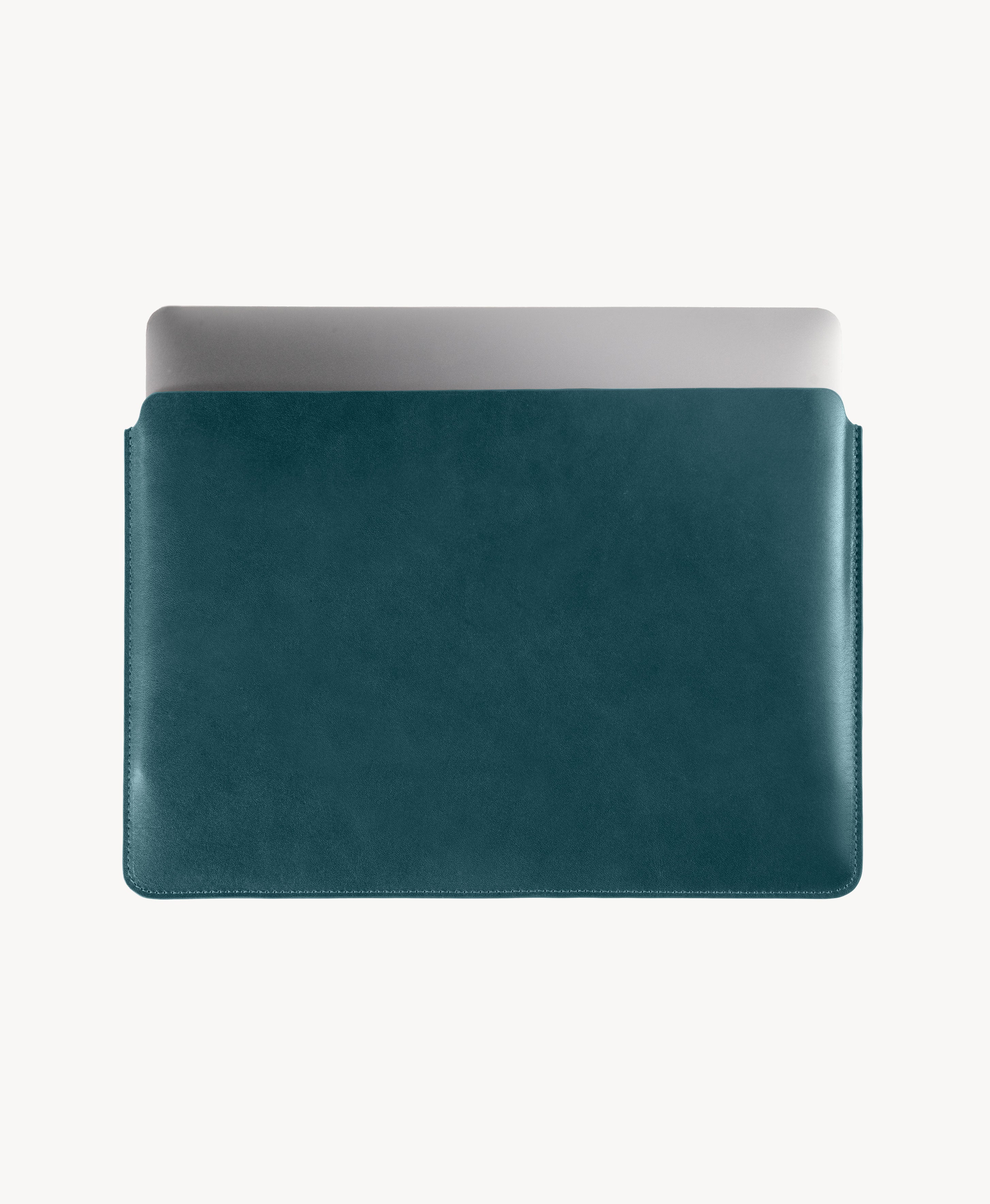 Blue full grain saddle leather laptop sleeve, MacBook partially inserted through the open top