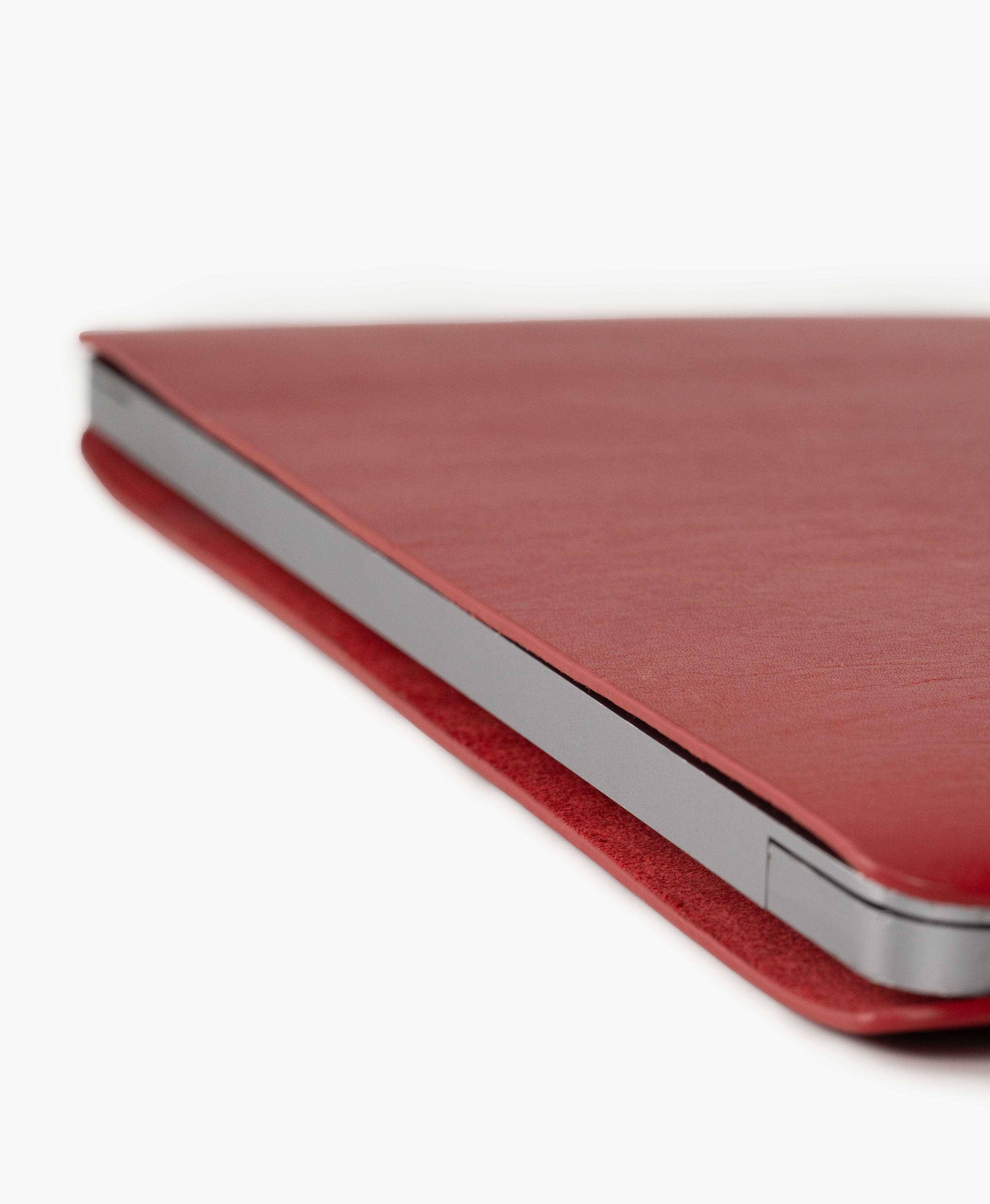 Red full grain saddle leather laptop sleeve, slim side profile with a MacBook inserted